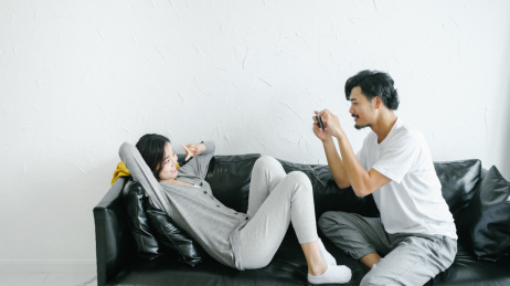 情侣坐在沙发上用手机拍照