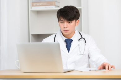 坐在办公室里正在工作的亚洲男医生