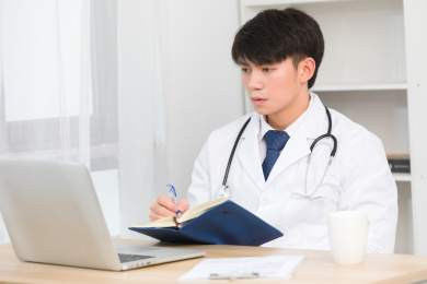 坐在办公室里正在工作的亚洲男医生