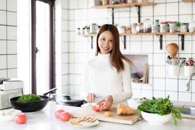一位年轻女性正在厨房里面做饭