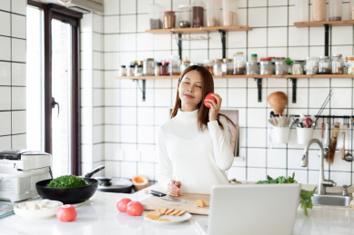 一位年轻女性正在厨房里面做饭