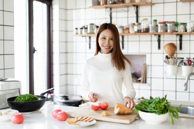 一位年轻女性正在厨房里面做饭