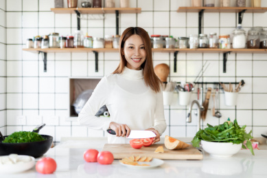 一位年轻女性正在厨房里面做饭
