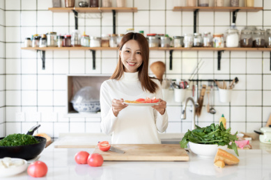 一位年轻女性正在厨房里面做饭