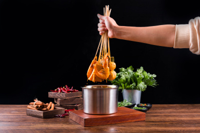 手握一把刚从火锅麻辣浓汤拿起的串串