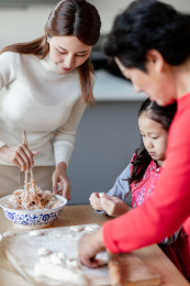 奶奶和妈妈在教小女孩包饺子
