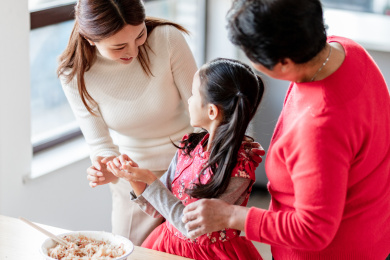 奶奶和妈妈在教小女孩包饺子