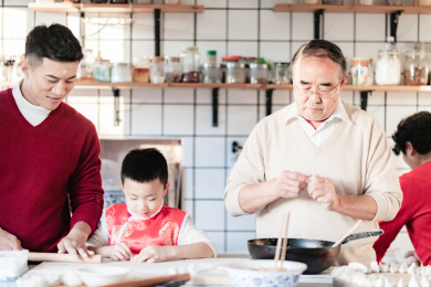 爸爸和爷爷在教小男孩包饺子