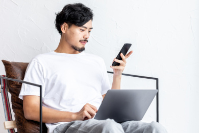一个年轻男人在客厅的沙发上使用手机