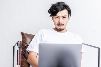 一个年轻男人在客厅的沙发上使用电脑