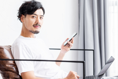 一个年轻男人在客厅的沙发上使用手机