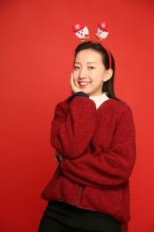 戴着雪人发卡托着下巴看向镜头的年轻美丽的中国女孩