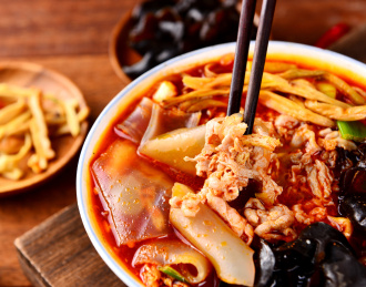 木纹背景上餐具里盛放的烩羊肉