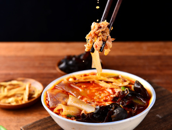 木纹背景上餐具里盛放的烩羊肉