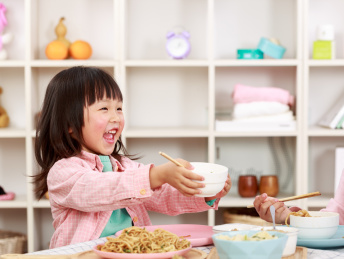 小女孩双手拿着小白碗叫妈妈盛饭