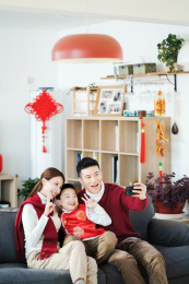 一家三口过年在沙发上拍照