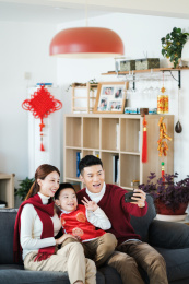 一家三口过年在沙发上拍照