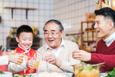 祖孙三代在饭桌前举杯庆祝