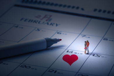 情人节的青年男女在爱心日历上拥抱亲吻