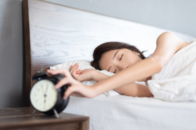 一名年轻漂亮女性躺在床上睡觉