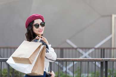 一名年轻女性购物逛街提着大包小包