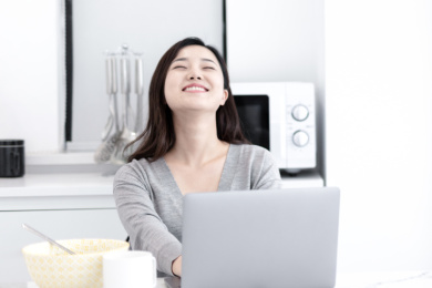 一个年轻的女人在家里使用电脑