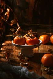 放在餐盘上的秋季水果，柿子