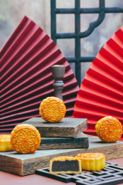 金黄色的可口豆沙馅月饼摆放在木桌上