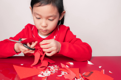 手工剪纸剪窗花的中国女孩