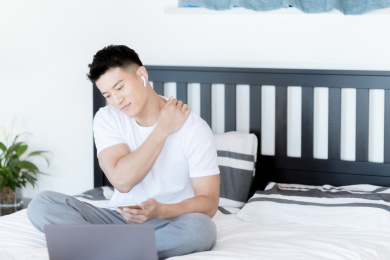 年轻人使用手机电脑在卧室移动办公