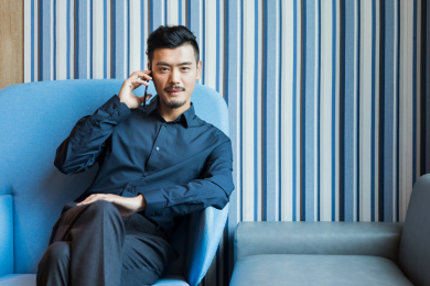 一位商务人士坐在沙发上接听电话