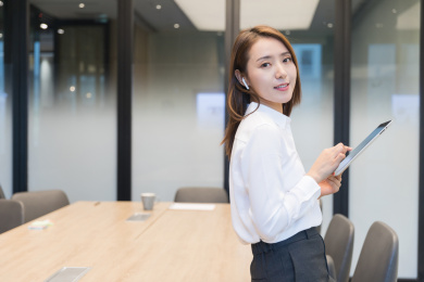 一位职场人士站在办公桌旁使用平板