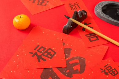 摆着红色背景上的笔墨纸砚和对联红包