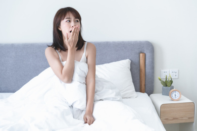 年轻女性一边打呵欠一边起床
