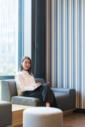 一位商务人士坐在沙发上手拿文件夹