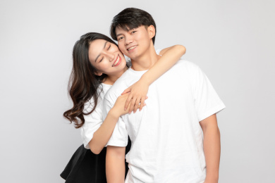 灰色背景里，拥抱在一起的亚洲年轻情侣