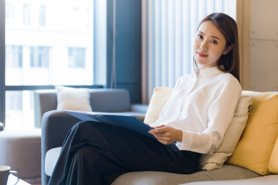 一位商务女性职场女性手拿文件夹坐在沙发上