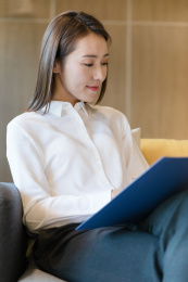 一位穿白衬衣的商务女性看文件