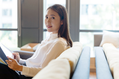 一位职场女性坐在沙发上手拿文件夹