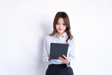 一名年轻的女性在商场外走廊上站立使用平板