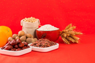 用瓷碟装有坚果和水果放在红色背景上