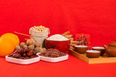 用瓷碗碟装有坚果和茶具及对联一同放在红色背景上