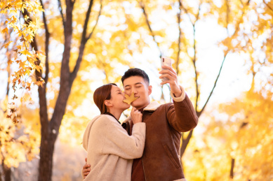 秋天情侣两人秋游用手机开心自拍和风景留念