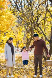 一家三口在秋天的树林里玩耍