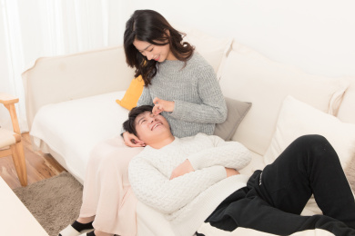  冬天一对亚洲年轻情侣坐在沙发上