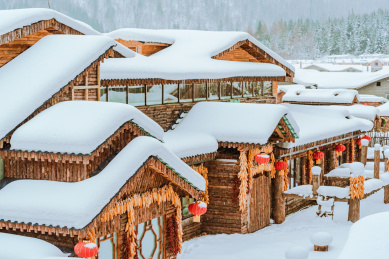 中国东北雪乡冬季屋顶堆着厚厚积雪的小木屋