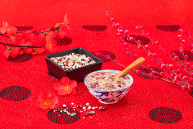 复古陶瓷碗装着的红豆西米腊八粥放在红色背景上