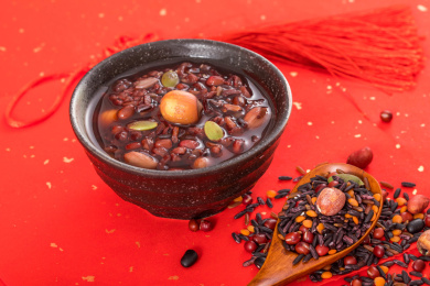 用黑色碗装着的甜食莲子黑米红豆腊八粥