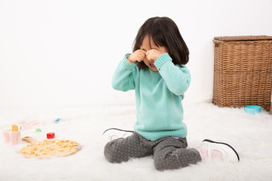 坐在地上扭过头去哭泣的小女孩