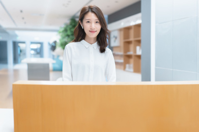 年轻亚洲商务女士站在服务台前